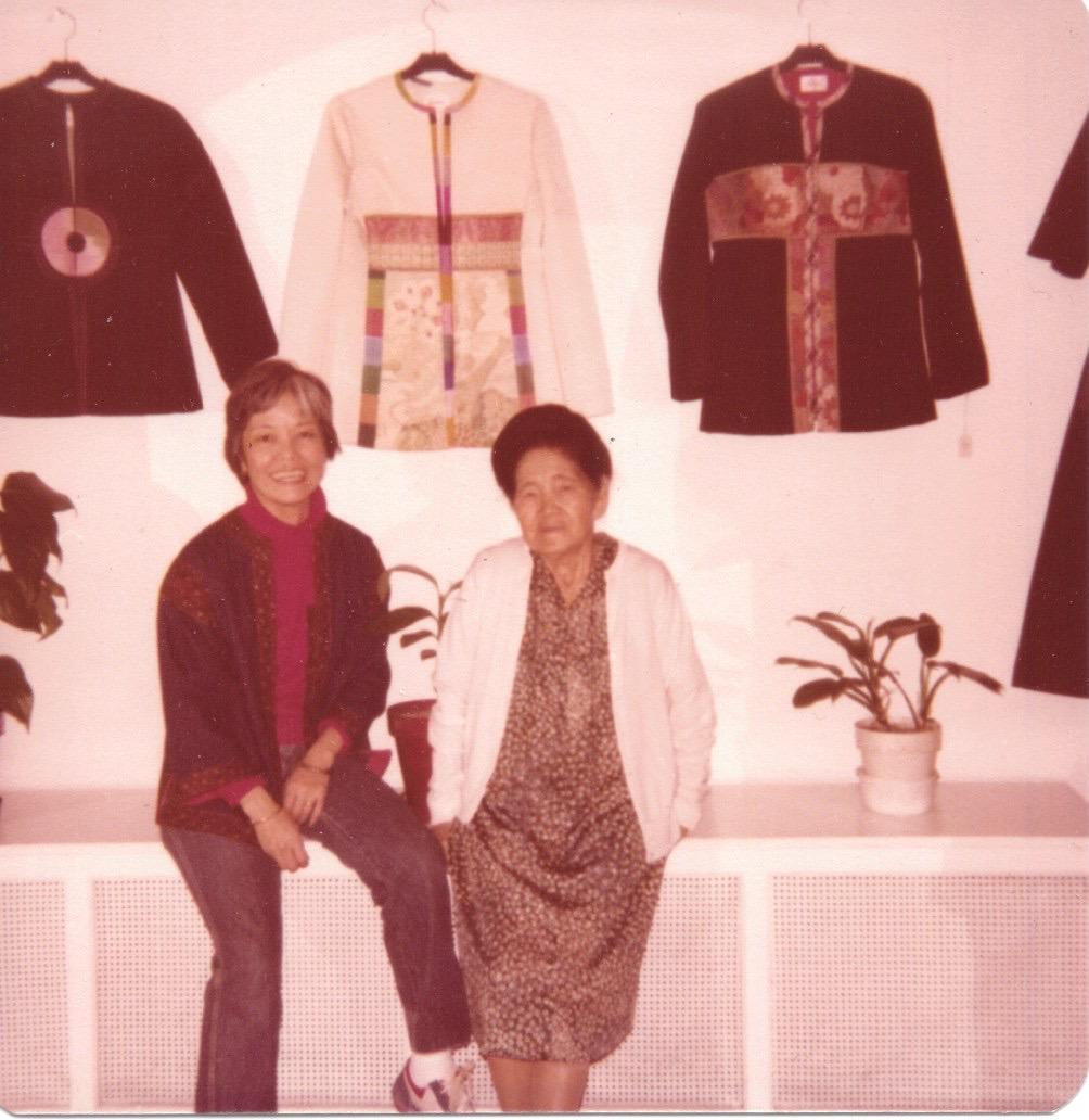 Fumi and her mom Mitsuko in front of Fumi's clothes.