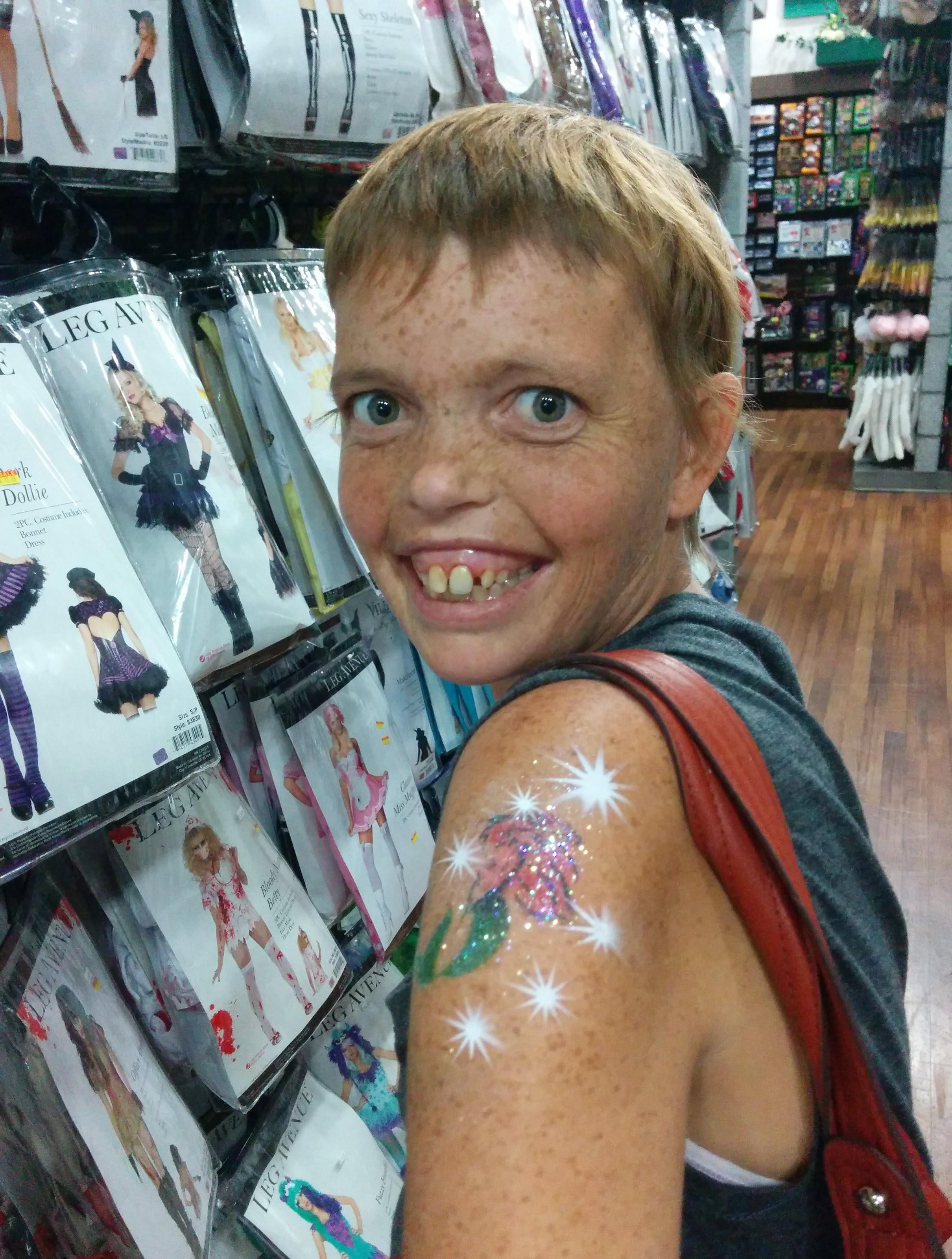 Freshly airbrushed tattooed looking at Halloween costumes.