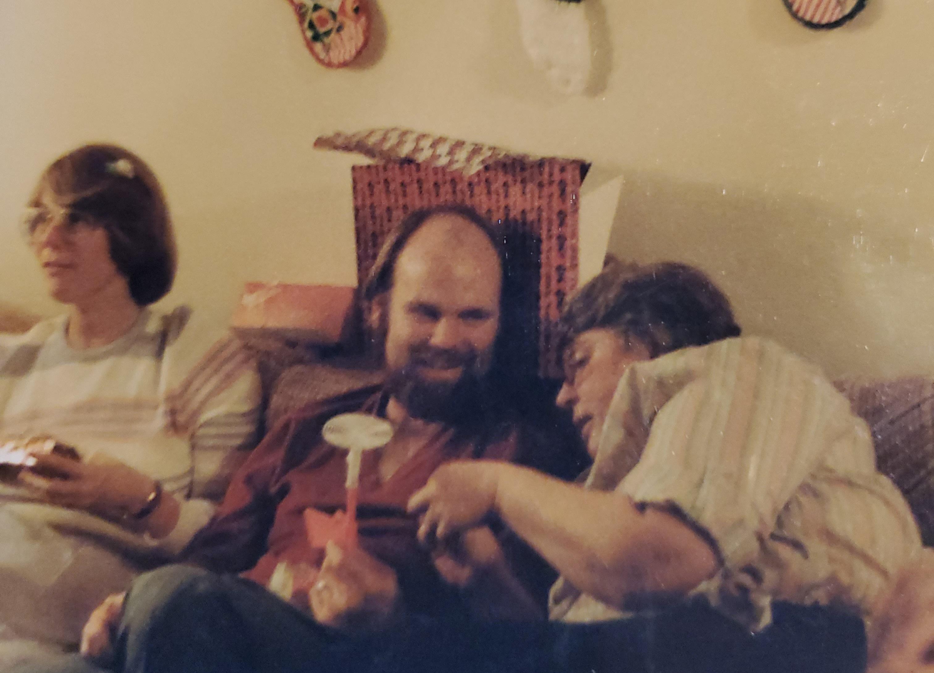 On our couch with sister Sandy and brother-in-law Wesley .  She had just given him a flyswatting gun for Christmas and was explaining the best way to ambush the fly! 