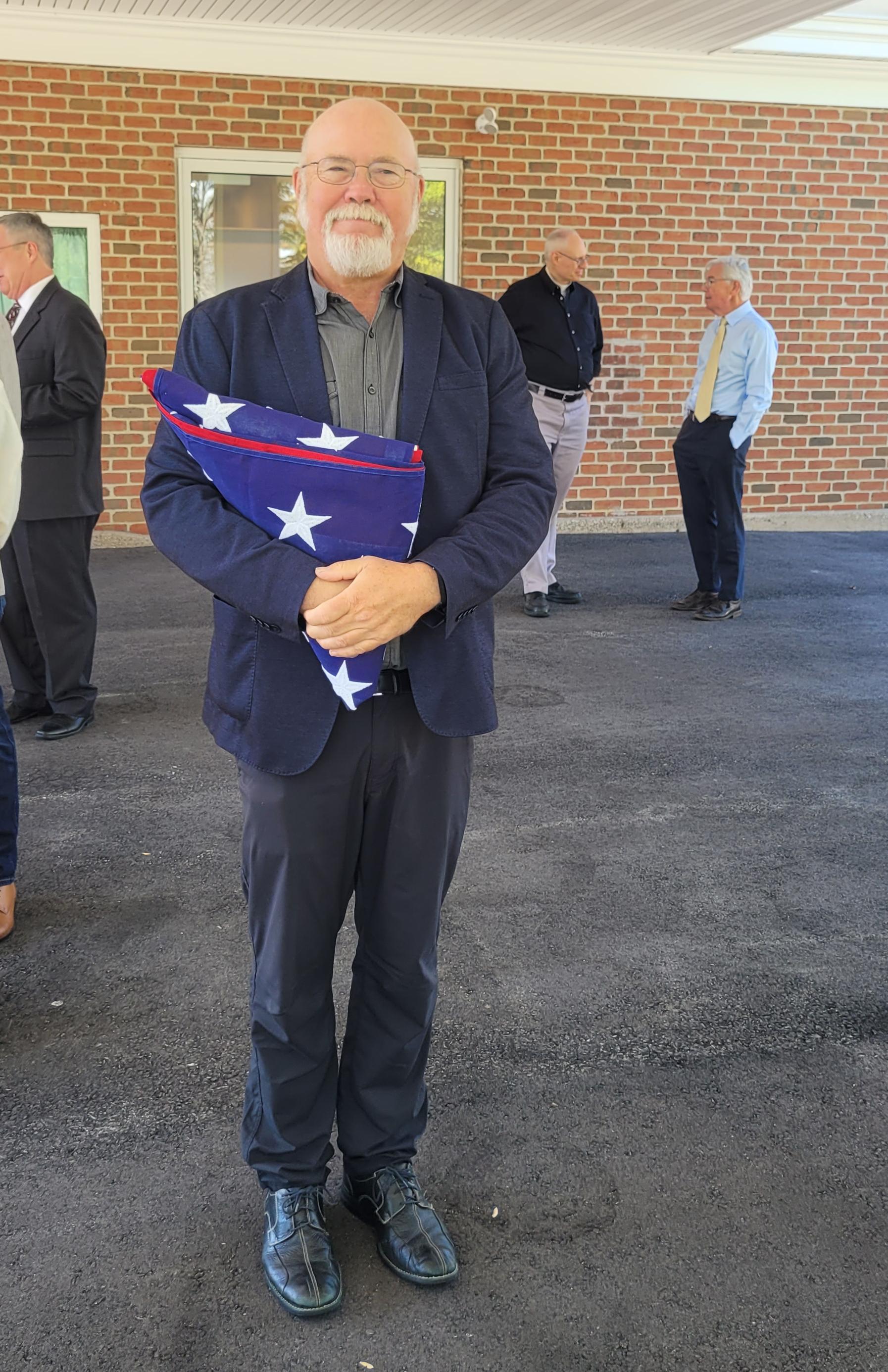 Bruce, Lyman's son, holding the military honors flag