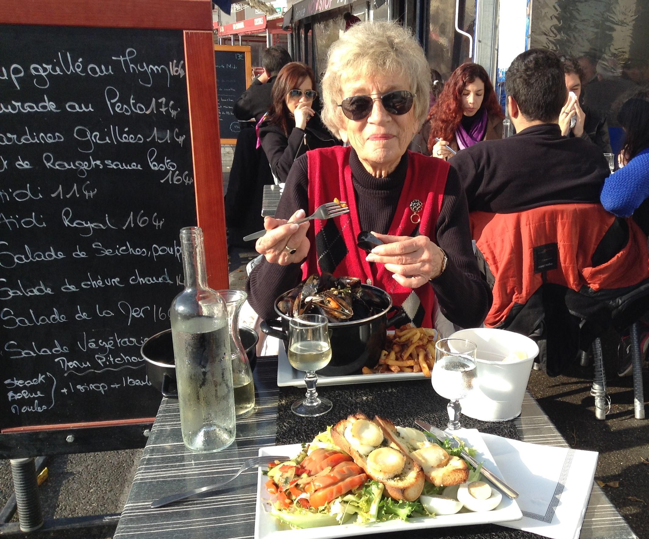 Mom enjoying moules et frites at an outdoor cafe in La Ciotat, a tiny French town on the Mediterranean Sea, December 2015